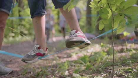 Children-on-a-summer-camp-hike-are-moving-along-the-ropes-a-close-up-of-a-child's-feet-on-a-rope